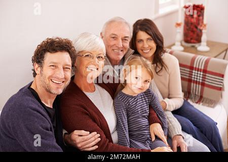 Visite des beaux-parents. Portrait court d'une famille de plusieurs générations heureuse assise ensemble sur un canapé. Banque D'Images