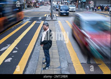 Hong Kong, Chine. 07th janvier 2023. Un piéton attend sur le trottoir pour un feu de signalisation qui devient vert à l'intersection de Zébra à Hong Kong. Crédit : SOPA Images Limited/Alamy Live News Banque D'Images