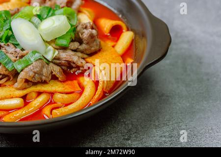 Tteokbokki, gâteau au riz frits par le fer : barre de gâteau au riz en tranches (garaetteok) ou fines bâtonnets de gâteau au riz (Tteokbokkkitteok) sautés dans une sauce piquante au gochujang Banque D'Images