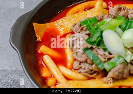 Tteokbokki, gâteau au riz frits par le fer : barre de gâteau au riz en tranches (garaetteok) ou fines bâtonnets de gâteau au riz (Tteokbokkkitteok) sautés dans une sauce piquante au gochujang Banque D'Images