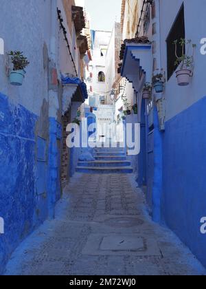 Façade bleuâtre dans la ville africaine de Chefchaouen au Maroc, ciel bleu clair en 2019 chaud et ensoleillé jour de printemps avril - vertical Banque D'Images