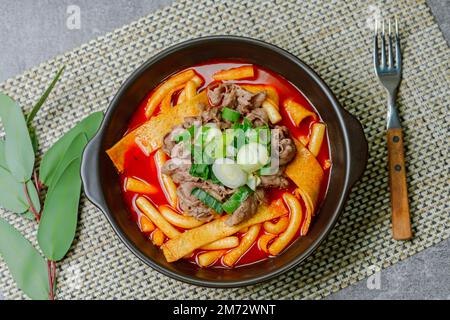 Tteokbokki, gâteau au riz frits par le fer : barre de gâteau au riz en tranches (garaetteok) ou fines bâtonnets de gâteau au riz (Tteokbokkkitteok) sautés dans une sauce piquante au gochujang Banque D'Images