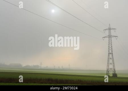 pôle de puissance unique avec brouillard dense et soleil au ciel en hiver Banque D'Images