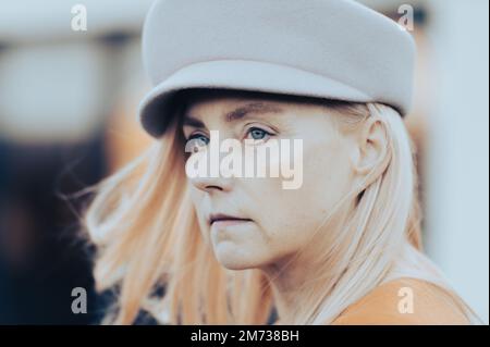 Gros plan portrait de visage européenne femme d'âge moyen avec des yeux bleus verts en automne chapeau mode Banque D'Images