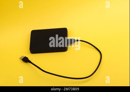 Disques durs externes noirs isolés sur fond jaune Banque D'Images