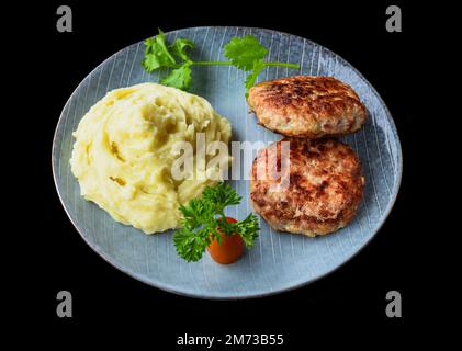 purée de pommes de terre avec des côtelettes de viande sur fond noir vue de dessus Banque D'Images