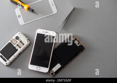 Technicien répare l'intérieur du téléphone portable par fer à souder. le concept de données, de matériel, de technologie. Banque D'Images