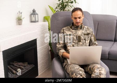 Surveillance et contrôle du concept d'information opposé, Soldier en uniforme de camouflage travaillant sur ordinateur portable pour opération d'information Banque D'Images