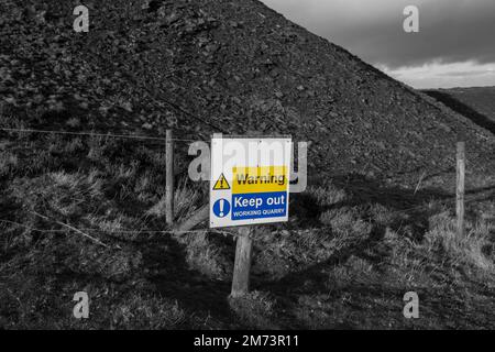 Avertissement garder à l'extérieur sur un poteau de clôture marquant la limite d'une carrière de travail. Avec couleur sélective Banque D'Images