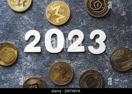 Crypto-monnaie en 2023. Crypto d'or pièces Bitcoin, Ethereum, Shiba, BNB, Monero, Polkadot à côté du numéro de l'année sur fond concret. 2023 concept de prévision des prix et des tendances du marché. Banque D'Images