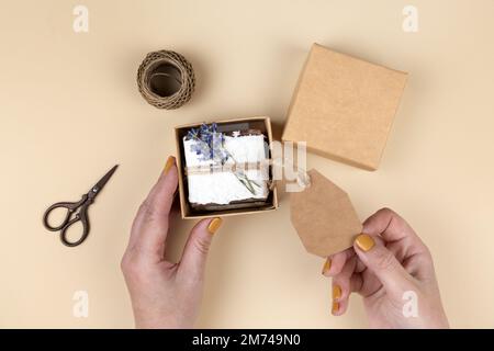 Savon maison naturel enveloppé de papier floral pressé fait à la main, décoré de lavande. Idée de cadeau d'entreprise ou personnelle. Cadeau pour la fête des femmes Banque D'Images