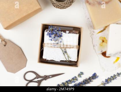 Savon maison naturel enveloppé de papier floral pressé fait à la main, décoré de lavande. Idée de cadeau d'entreprise ou personnelle. Cadeau pour la fête des femmes Banque D'Images