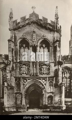 Thaxted, Essex, Angleterre. Vers. 1930s. Une carte postale vintage intitulée "le porche du Nord, l'église de Thained". Dépeint l'église Saint Jean-Baptiste avec notre Dame et Saint Laurence, qui est l'église paroissiale de la ville de Thaxted dans Essex, Angleterre. L'église actuelle a été construite sur une période prolongée entre 1380 et 1510 dans le style perpendiculaire anglais. Banque D'Images