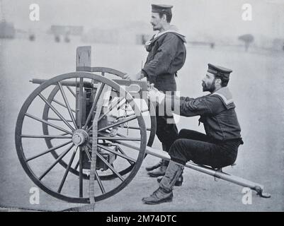 « Maxim Gun Practice at Whale Island, Portsmouth ». Vers.1895. Deux marins de la Marine royale du HMS excellent, le navire d'artillerie de Portsmouth, pratiquent avec un fusil Maxim, le dernier type de mitrailleuse adopté par la Marine. La particularité du Maxim (ainsi nommé d'après son inventeur) est son action automatique. Le firer appuie sur un bouton et le canon continue à tirer par lui-même jusqu'à ce que ses munitions, portées sur une ceinture de 150 à 200 cartouches, s'arrêtent. Les courroies sont rapidement remplacées, et 600 coups par minute, dans un flux continu de balles, peuvent être tirés. Banque D'Images