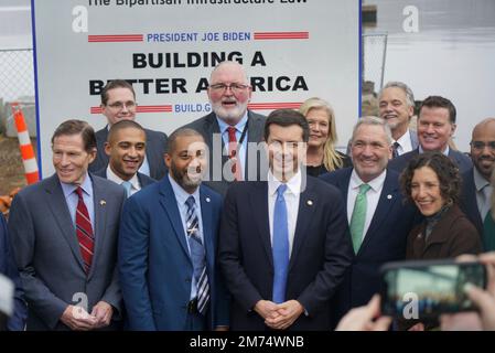 New London, États-Unis d'Amérique. 04 janvier 2023. Le secrétaire américain aux Transports, Pete Buttigieg, au centre, pose avec des politiciens et des teamsters locaux et régionaux à la suite d'un événement organisé sous le Gold Star Memorial Bridge au lancement de bateaux sur la Tamise, à 4 janvier 2023, à New London, Connecticut. L'Administration Biden-Harris a alloué $158 millions de dollars pour remettre en état le lien critique sur le corridor de l'Interstate 95. Banque D'Images