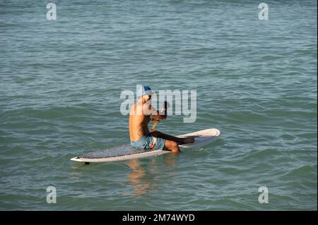 Honolulu, Hawaï - 26 décembre 2022 : homme se préparant à pagayer sur la célèbre plage de Waikiki. Banque D'Images