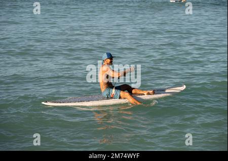 Honolulu, Hawaï - 26 décembre 2022 : homme se préparant à pagayer sur la célèbre plage de Waikiki. Banque D'Images