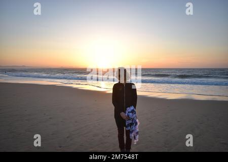 Coucher de soleil et Femme au Foulard sur la plage de Capbreton (plage de l'Estacade, Capbreton, Landes, Sud-Ouest de la France, Sud-Ouest de la France) Banque D'Images