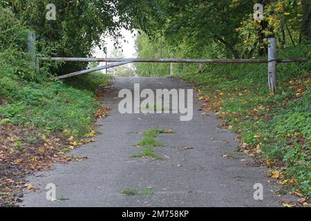 Barrière sur une route en asphalte abandonnée. Banque D'Images