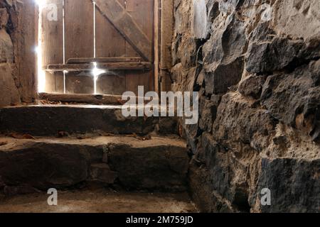 Escaliers en pierre dans l'ancienne forteresse. Ancienne porte en bois à l'étage Banque D'Images