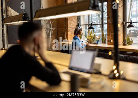 Une femme travaille sur un ordinateur portable au café Banque D'Images