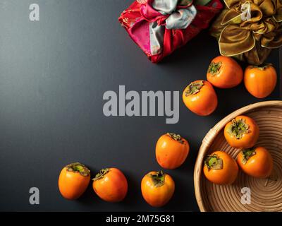 Cadeau traditionnel coréen avec des persimmons sur fond sombre Banque D'Images