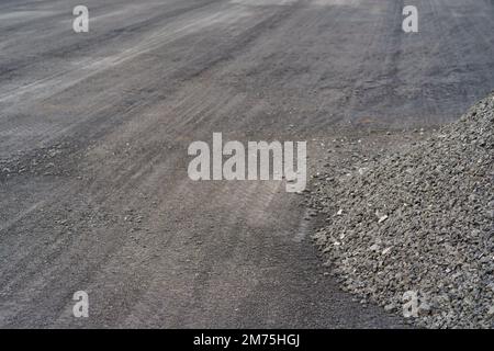 Réparation de la route avec une pile de débris de construction laissés après l'enlèvement de l'ancienne couche d'asphalte Banque D'Images