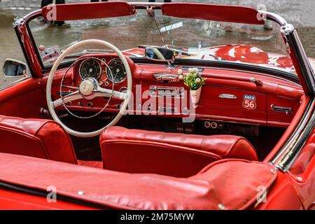 Vue de l'intérieur de la voiture classique cabriolet Mercedes SL 190 avec cuir rouge, volant à rayons blancs, tableau de bord avec vase à fleurs, Düsseldorf Banque D'Images