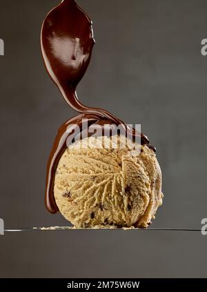 chocolat fondu sur boule de glace caramel sur fond gris Banque D'Images