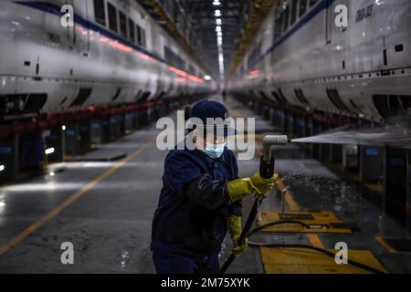 Wuhan, Hubei, Chine. 7th janvier 2023. Un travailleur nettoie un train à grande vitesse CRH à la base de Wuhan. Environ 6,3 millions de voyages de passagers devraient être effectués en Chine samedi, le premier jour de la course de voyage du Festival de printemps de cette année, a déclaré l'opérateur ferroviaire national China State Railway Group. La Chine a récemment optimisé sa gestion de la lutte contre les épidémies et les mesures épidémiques pour les voyages ont également été optimisées le mois dernier. Les voyageurs n'ont plus besoin de résultats négatifs de tests d'acides nucléiques ou de codes de santé, ne sont plus tenus de subir de tests d'acides nucléiques ou d'inspection sanitaire à leur arrivée, an Banque D'Images