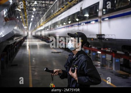 Wuhan, Hubei, Chine. 7th janvier 2023. Un technicien vérifie un train à grande vitesse CRH à la base de Wuhan. Environ 6,3 millions de voyages de passagers devraient être effectués en Chine samedi, le premier jour de la course de voyage du Festival de printemps de cette année, a déclaré l'opérateur ferroviaire national China State Railway Group. La Chine a récemment optimisé sa gestion de la lutte contre les épidémies et les mesures épidémiques pour les voyages ont également été optimisées le mois dernier. Les voyageurs n'ont plus besoin de résultats de tests négatifs sur les acides nucléiques ou de codes de santé, ne sont plus tenus de subir de tests d'acides nucléiques ou d'inspection sanitaire à leur arrivée Banque D'Images