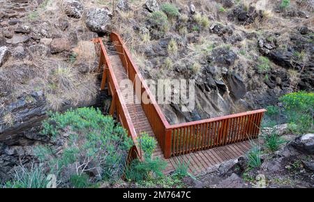 Pont sur le ruisseau de montagne Meshushim. Nahal Meshushim. Roches sous forme de colonnes de basalte hexagonales. Israël Banque D'Images