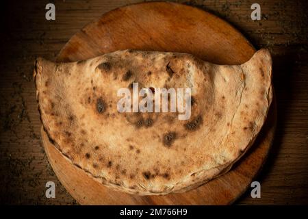 calzone pizza sur plaque de bois vue sur le dessus. Banque D'Images