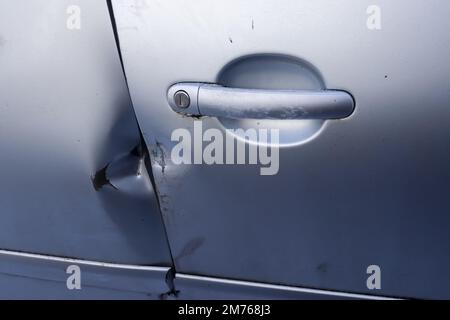 Porte de voiture avec des marques de rodage provenant d'un pied-de-biche près de la poignée Banque D'Images