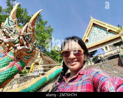 Un jeune touniste prenant selfie de l'entrée de Wat Khao rang un temple bouddhiste thaïlandais sur l'île de Phuket, Thaïlande. Banque D'Images