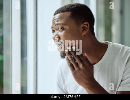 Soin de la peau, homme noir et stress d'acné au miroir dans la salle de bains à la maison avec le visage inquiet et confus. Homme malheureux vérifiant le bouton et le problème de tête noire dans Banque D'Images