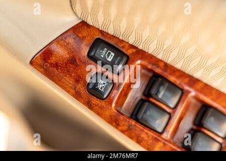 Bouton de verrouillage et de déverrouillage de la vitre de la voiture sur le bras d'une porte du côté conducteur Banque D'Images