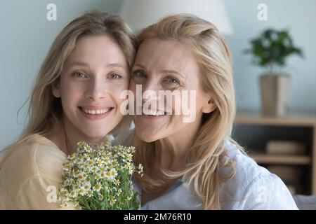 Bonne fille adulte et mère blonde senior posant avec des sourires Banque D'Images