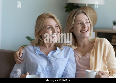 Une mère âgée et une fille adulte gaies assises sur un canapé ensemble Banque D'Images