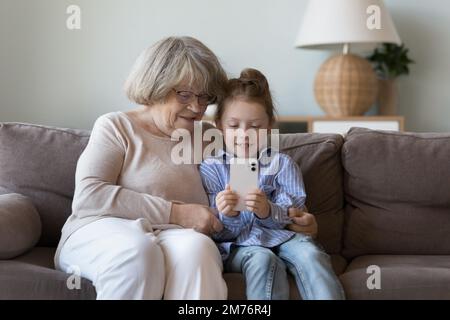 Grand-mère d'âge grand-mère regardant la petite-fille à la maison Banque D'Images