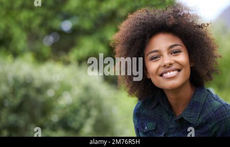 Un peu d'air frais. Portrait d'une jeune femme souriante dehors dans un jardin. Banque D'Images