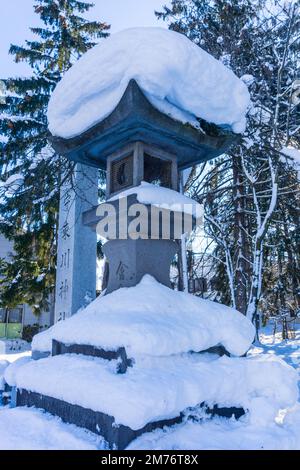 Grande lanterne en pierre toro couverte de neige au sanctuaire de Higashikawa en hiver dans la ville de Higashikawa, Hokkaido, au nord du Japon Banque D'Images