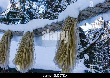 Shimenawa enneigé ou corde de paille shinto au sanctuaire de Higashikawa au nouvel an dans la ville de Higashikawa, Hokkaido, nord du Japon Banque D'Images