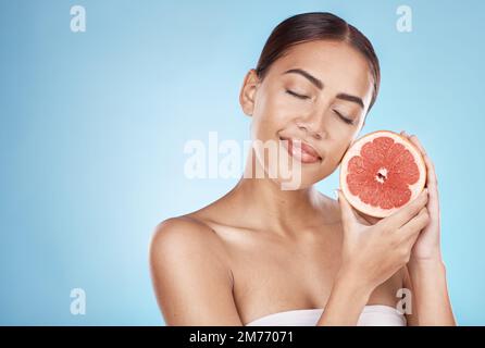 Soin de la peau, pamplemousse et bonne femme de bien-être satisfait avec la vitamine c soin du corps luminescent traitement. Esthétique, détox et modèle cosmétique naturel en bleu Banque D'Images