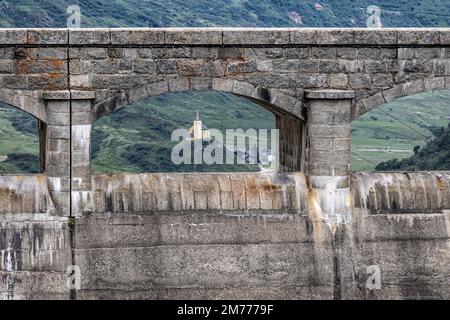 Vue sur la petite église de Sant'Anna à travers le barrage du lac Morasco dans le village de Riale dans la vallée de Formazza, à Verbano-Cusio-Ossola, Italie Banque D'Images