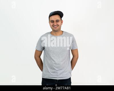 Gros plan en studio photo de jeune adulte à la peau brune debout et souriant à l'appareil photo. Espace pour le texte. Banque D'Images