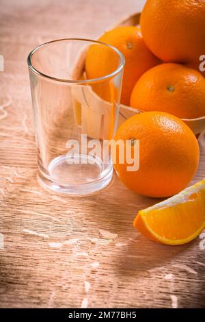 oranges en seau sur table en bois avec verre vide nourriture et boisson concept Banque D'Images