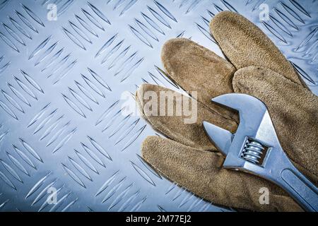 Gants de sécurité clé réglable sur plaque métallique rainurée concept de construction. Banque D'Images