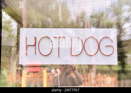 Affiche suspendue avec hot dog écrit derrière le verre Banque D'Images