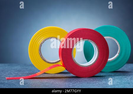 trois rouleaux de ruban isolant de couleur sur fond gris Banque D'Images